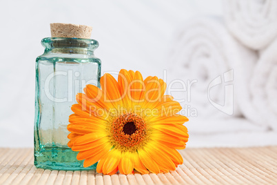 A glass phial and a sunflower with white towels