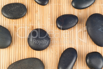 Black stones against bamboo background