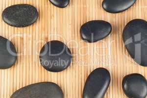 Black stones against bamboo background
