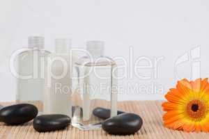 Sunflower with black stones and massage oil bottles
