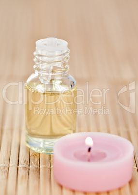 Pink lighted candle and glass phial