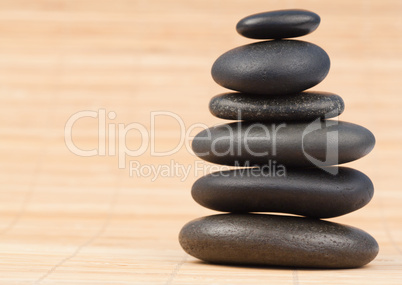 Black stones stack against bamboo background