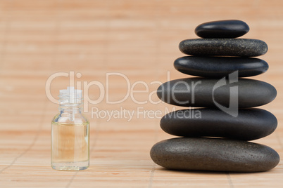 Close up of a glass phial and a black pebbles stack