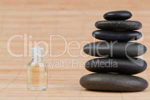 Close up of a glass phial and a black pebbles stack