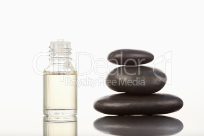 Black pebbles stack and a glass phial