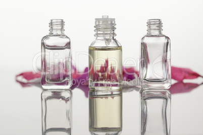 Glass flasks and pink petals focus on the flasks