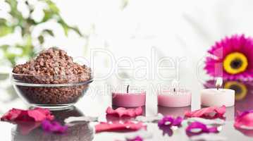 Lighted pink candles with petals and a bowl of gravel