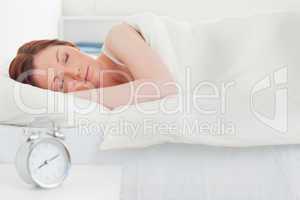 Beautiful red-haired woman sleeping in her bed