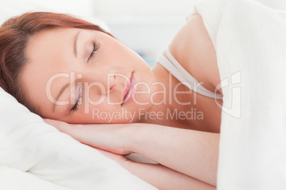 Close-up of a beautiful red-haired woman sleeping in her bed