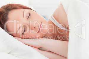 Close-up of a beautiful red-haired woman sleeping in her bed