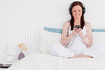 Attractive red-haired woman listening to music with her headphon