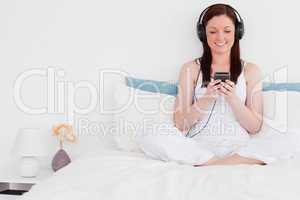 Attractive red-haired woman listening to music with her headphon