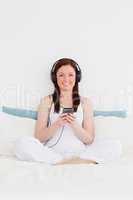Beautiful red-haired woman listening to music with her headphone