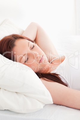 Close-up of a gorgeous red-haired woman sleeping in her bed