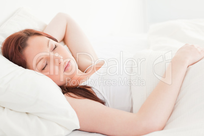 Close-up of a cute red-haired woman sleeping in her bed