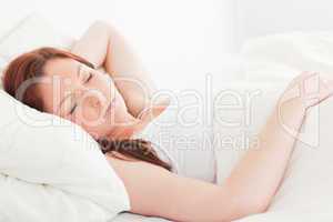 Close-up of a cute red-haired woman sleeping in her bed