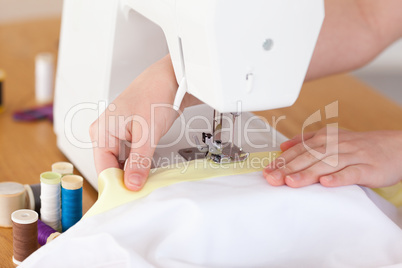 Caucasian hands using a sewing machine in the living room