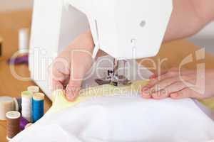 Caucasian hands using a sewing machine in the living room