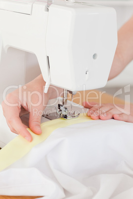 Caucasian hands using a sewing machine in the living room