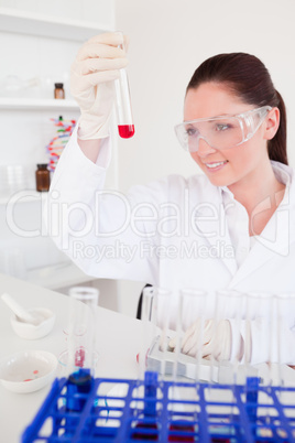 Pretty red-haired woman holding a test tube