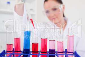 Attractive red-haired scientist filling up a test tube