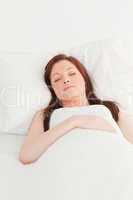 Close-up of a gorgeous red-haired female sleeping in her bed