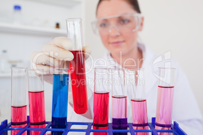 Beautiful red-haired woman holding a test tube