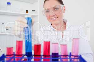 Beautiful red-haired female holding a test tube