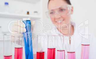 Attractive red-haired female holding a test tube