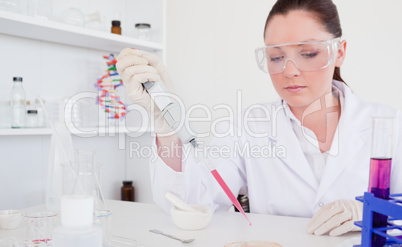 Beautiful red-haired scientist using a pipette