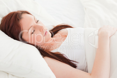 Close-up of a cute red-haired female sleeping in her bed