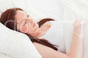 Close-up of a cute red-haired female sleeping in her bed