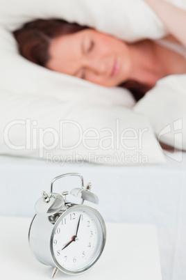 Attractive red-haired female sleeping in her bed