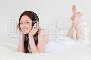 Attractive red-haired female relaxing with her headphones while