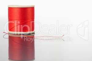 Red spool of thread on a table
