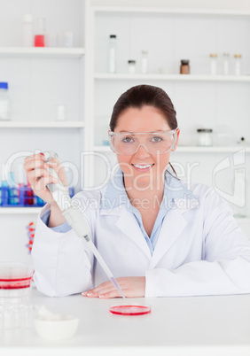 Young scientist preparing a sample while looking a the camera