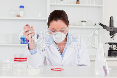 Young scientist preparing a sample while wearing a protective ma