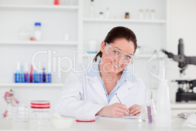 Young scientist preparing  her report looking at the camera