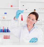 Cute scientist looking at a test tube