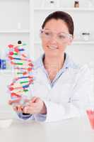 Cute scientist showing the dna double helix model