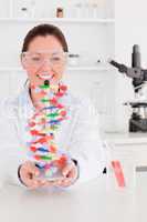 Portrait of a smiling scientist showing the dna double helix mod