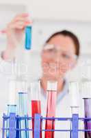 Young scientist looking at test tubes with the camera focus on t