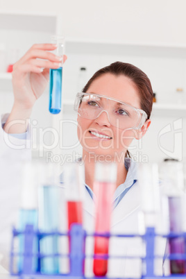 Portrait of a cute scientist looking at test tubes