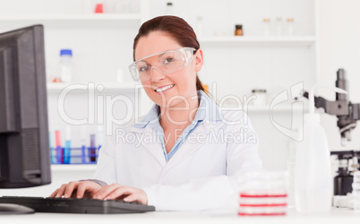 Young scientist typing a report with her computer