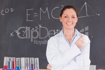 Young scientist holding a piece of chalk while standing in front