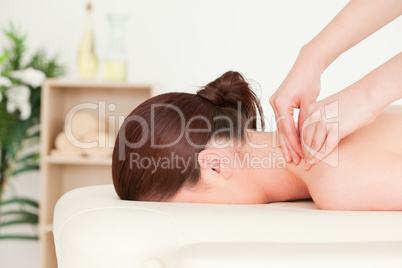 Red-haired woman receiving a back massage