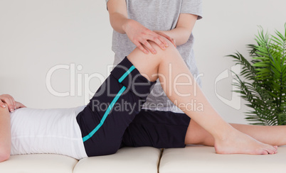Masseuse massing the knee of an athletic woman