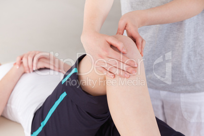 Masseuse massing the knee of a sportswoman