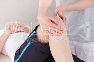 Masseuse massing the knee of a sportswoman