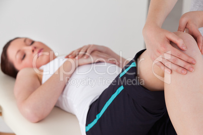 Masseuse massing the knee of a young woman